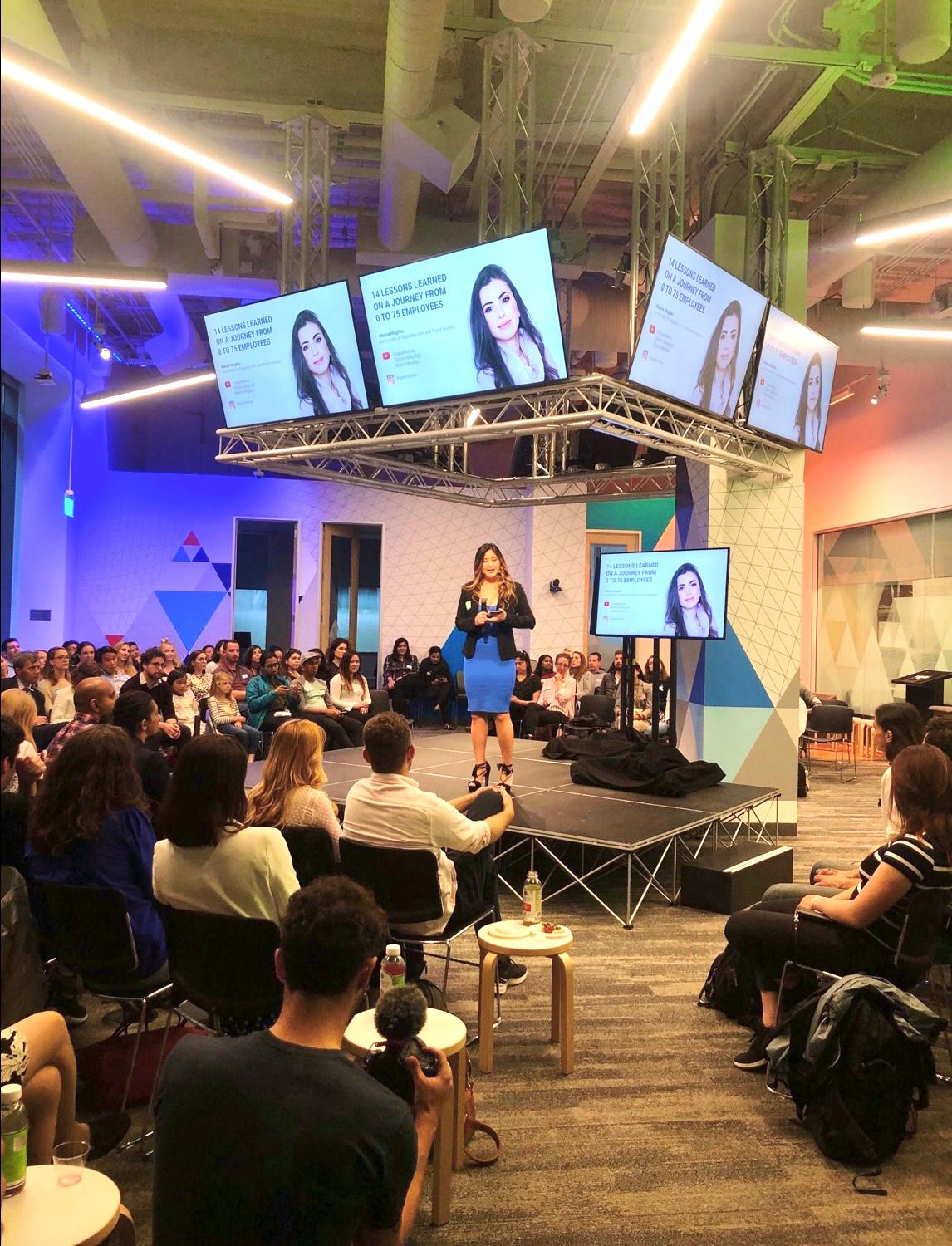 A speaker addressing a seated audience at a Vela event